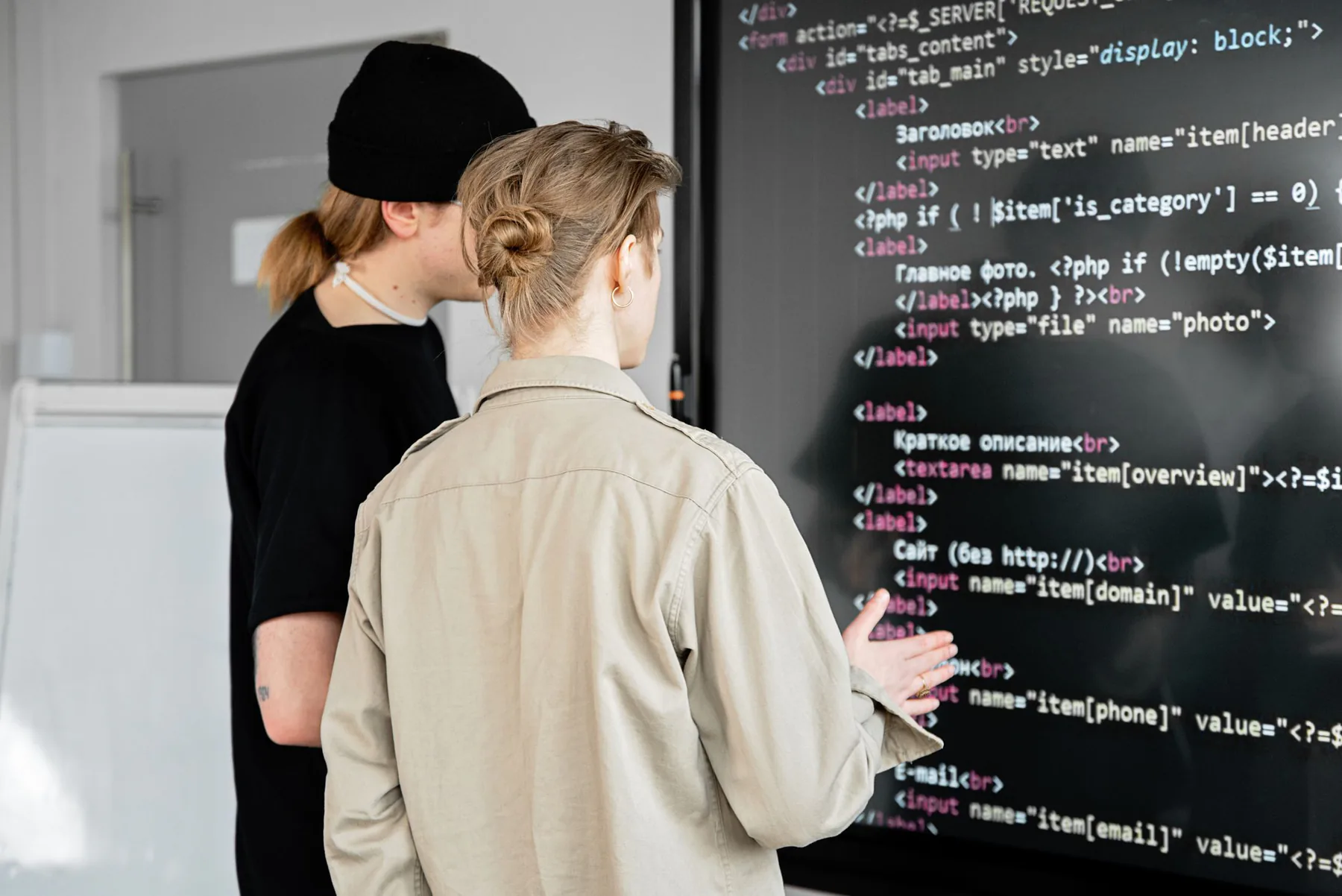 Developers reviewing code on a large display.