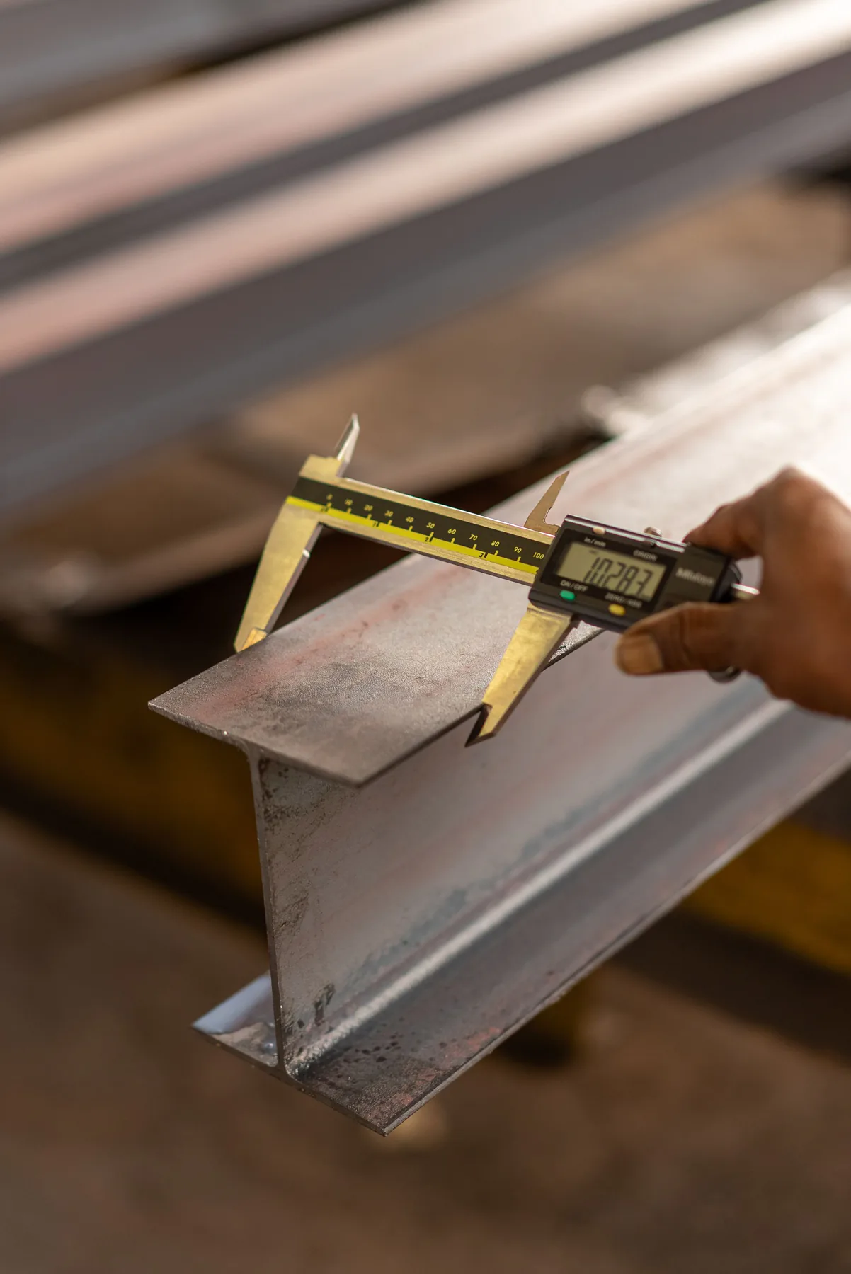 A caliper measuring a steel part.